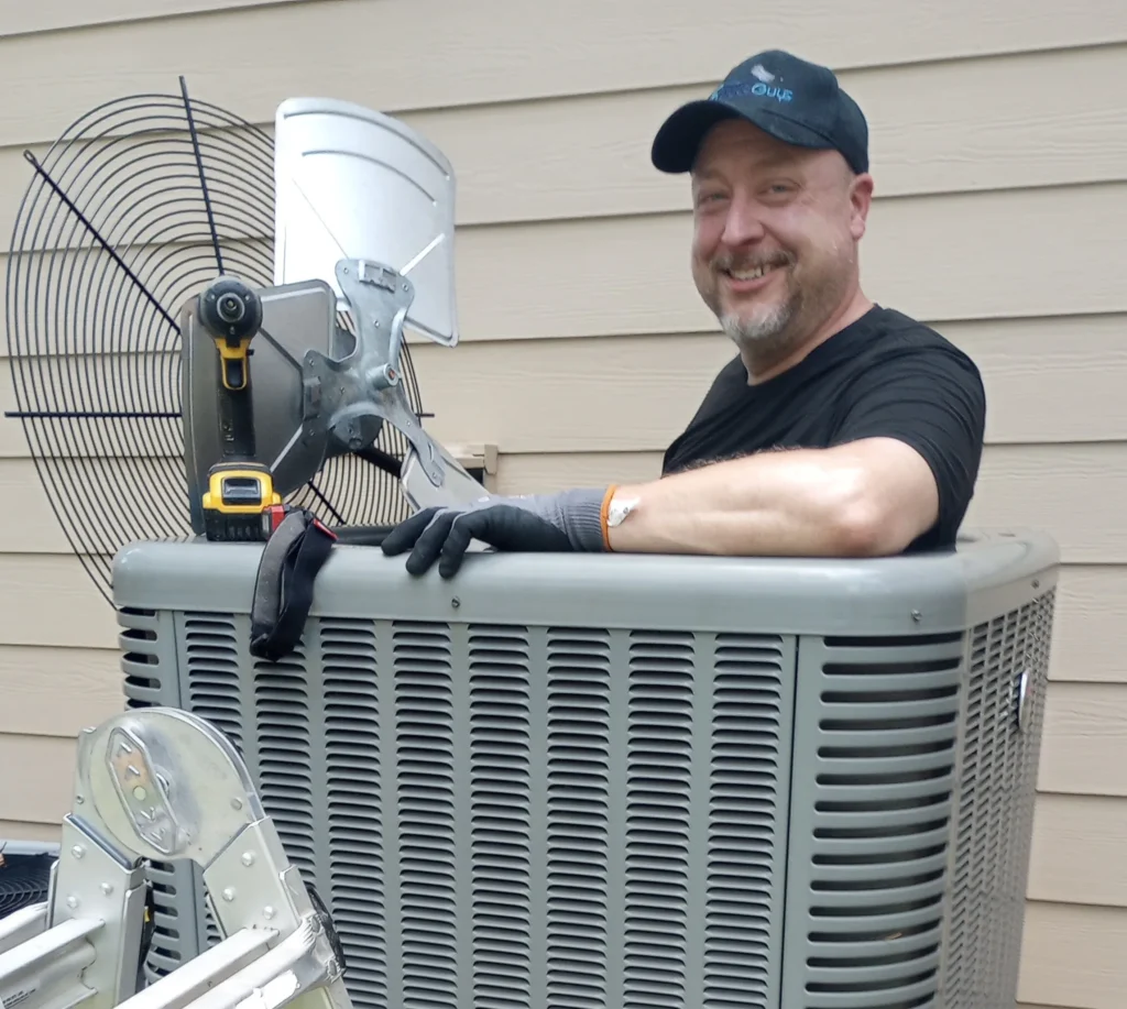 Duct Guys HVAC technician inspecting an outdoor condenser